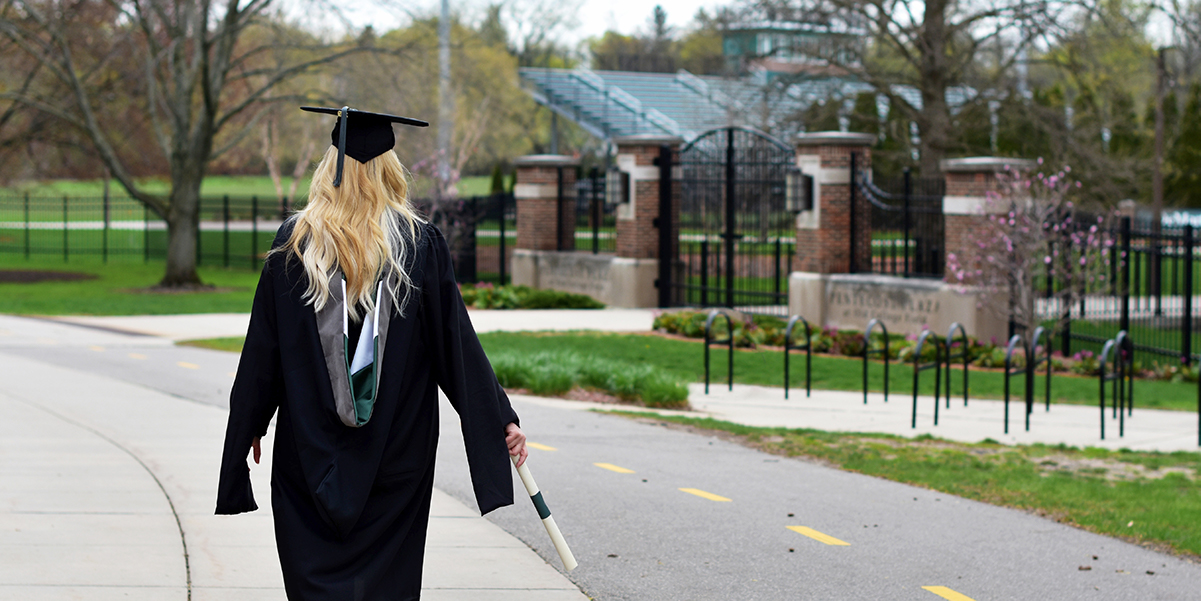 woman graduate walking with diploma