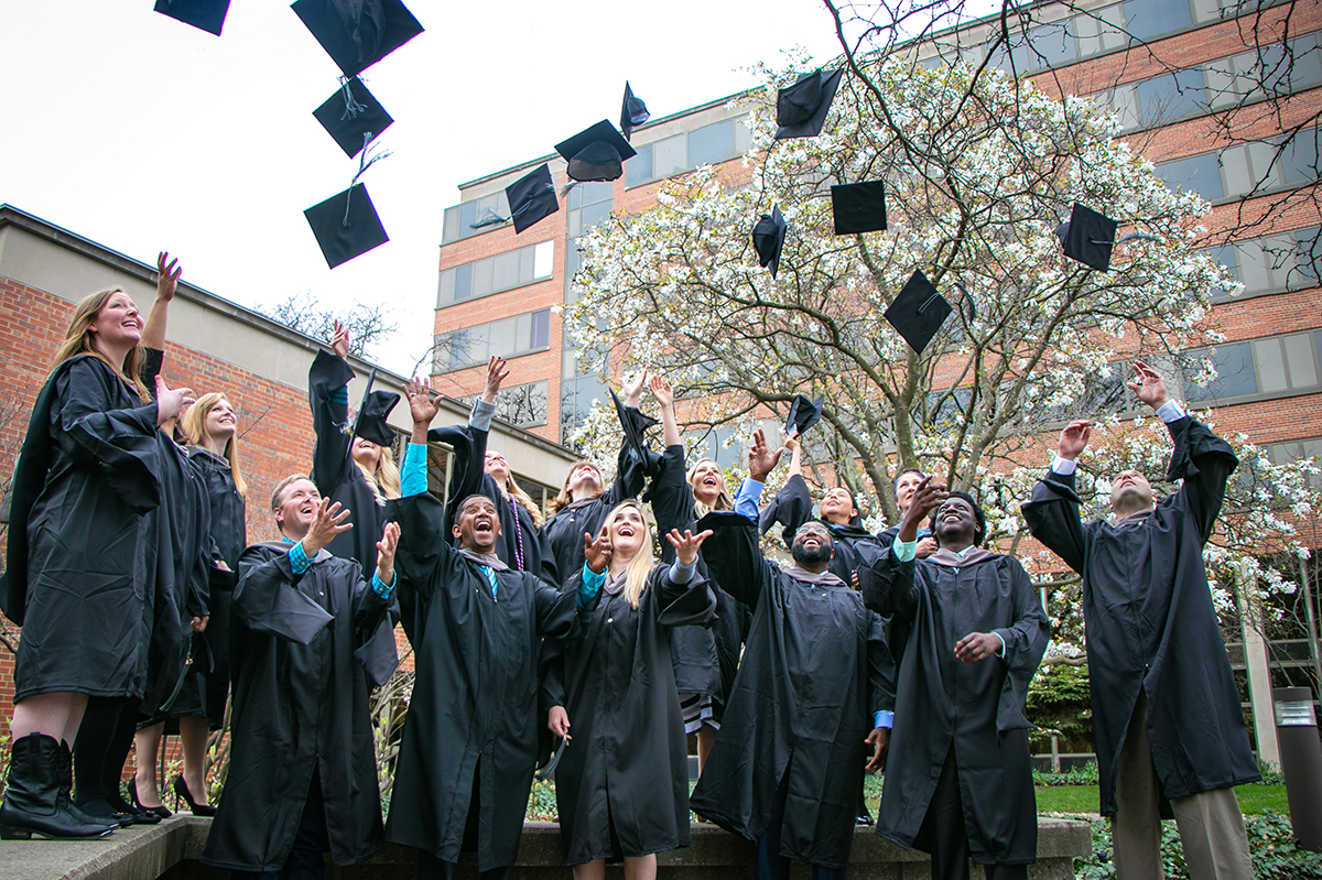 graduates throwing their caps up in the air